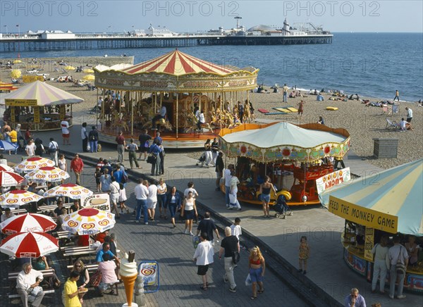 ENGLAND, East Sussex, Brighton, Seafront Carousels & cafe summertime.