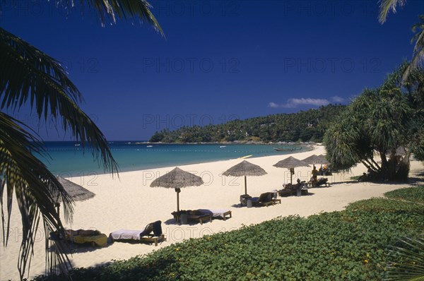 THAILAND, Phuket , Chedi Beach, View over sandy beach with sun parasols towards calm turquoise sea