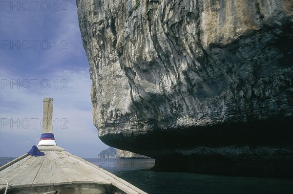 THAILAND, Krabi, Phi Phi Leh, Undercut rock face seen from the bow of a long tail boat