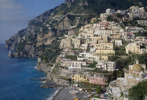 ITALY, Campania, Amalfi Coast, Near Positano. Elevated view towards hillside town buildings overlooking the beach and sea