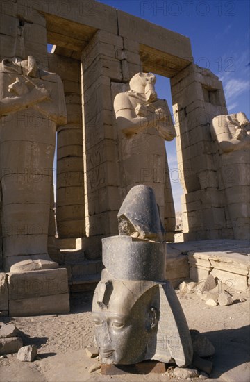 EGYPT, , Luxor, Osirid columns in front of temple with head of statue on ground