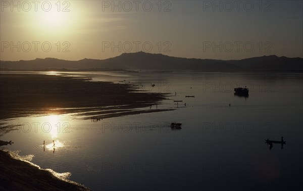Myanmar, Pagan, View over Irawaddy river at dusk or dawn with the sun in left corner reflecting off water