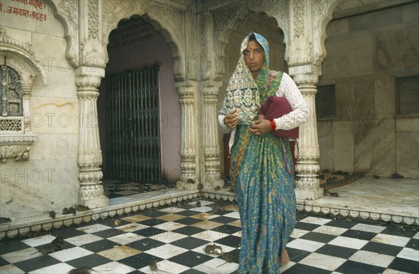 INDIA, Rajasthan , Deshnok, Interior of Karni Mata Temple near Bikaner with woman worshipper in tradtional dress feeding the rats that inhabit the temple.
