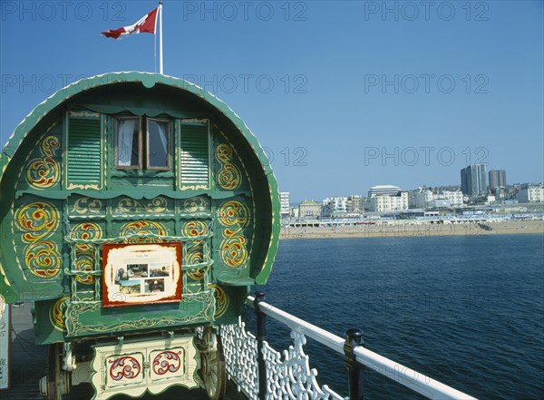 ENGLAND, East Sussex , Brighton, Brighton Pier Gypsy Caravan with Kemptown skyline behind .