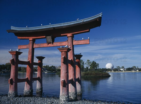 USA, Florida , Orlando , Walt Disney Epcot Centre. A red Japanese Torri Gate on lake with Spaceship Earth seen from across water