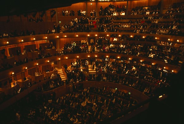 ENGLAND, East Sussex, Glyndebourne, Interior of auditorium with audience members taking their seats before Opera performance.