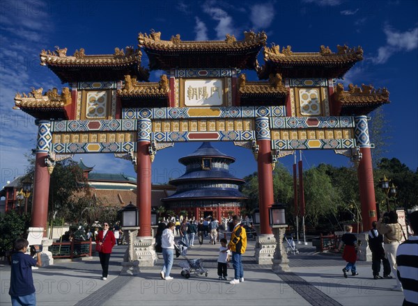 USA, Florida , Orlando, Walt Disney Epcot Center Chinese Showcase with visitors entering the China Pavilion through a large colourful Chinese gate with the Temple of Heaven seen further along