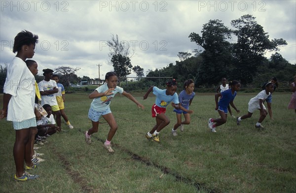 10068036 JAMAICA Sport Children competing in running race during school sports day.