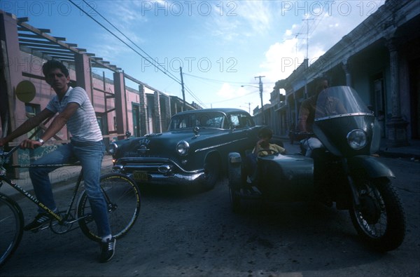 CUBA, Los Pinos , "Mixed traffic of bicycle, motorbike and sidecar and taxi"
