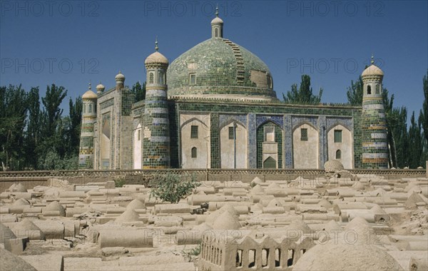 CHINA, Xinjiang, Kashgar , Abakh Hoja Tomb burial place of Hidajetulla Hoja and his decendants. Domed building with green tiles viewed across a dusty graveyard