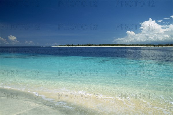INDONESIA, Lombok, Gili Islands, Gili Trawangan looking across clear water toward Gili Meno from the beach