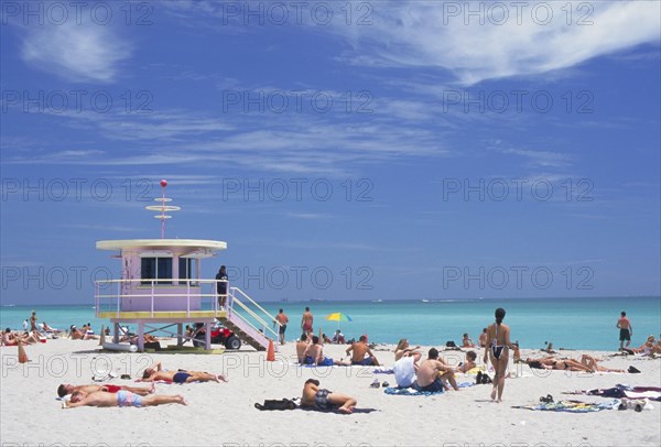USA, Florida, Miami, Sunbathers on the beach by a colourful lifeguard hut