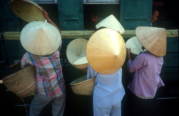 VIETNAM, Hue, Women selling hats to train passengers from platform