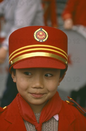 CHINA, Sichuan Province, Chengdu,  Portrait of young Boy in band wearing red and gold hat