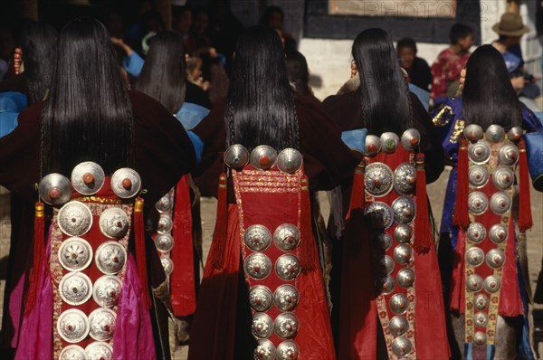 CHINA, Guizhou, Tongren, Tibetan dancers at a festival wearing traditional costumes with silver ornamental designs