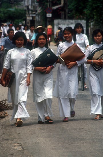 VIETNAM, Tam Ky, Line of young female students in traditional white dress.