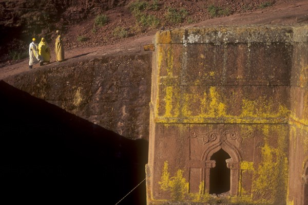 ETHIOPIA, Wolo Province, Lalibela, Bet Giorigos excavated Church of of St George with pilgrims standing on rim looking over the below ground church