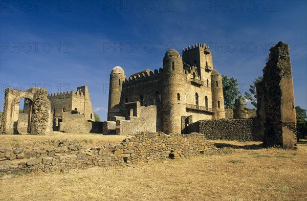 ETHIOPIA, Gonder, Ruins of Fasilides, Royal Enclosure at Fasils Castle. Stone fort with crumbling wall in the foreground