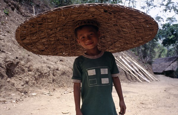 THAILAND, North, Mae Hong Son, Mae Yet camp. Karen refugee boy wearing a wide brimmed circular hat