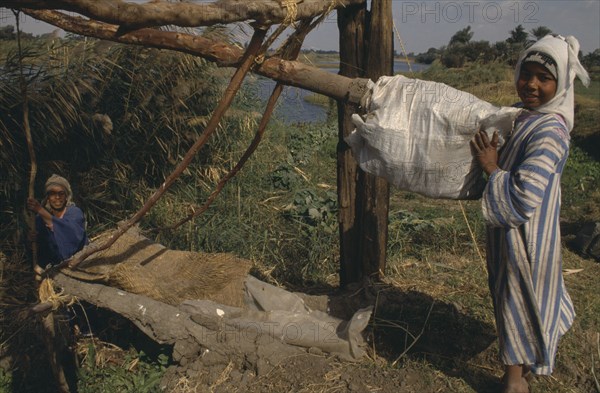 EGYPT, Luxor, Child using Shaduf Irrigation system