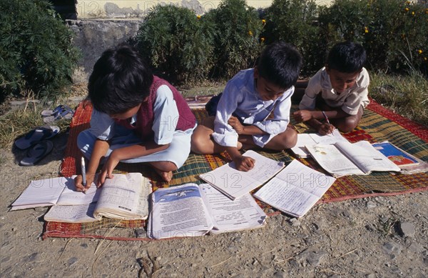 SRI LANKA, Children, Schools, "School children doing school work at a country school, outside on a blanket"