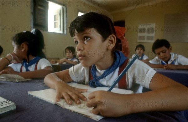 CUBA, , Holguin, Children in classsroom writing whilst looking toward top of the class