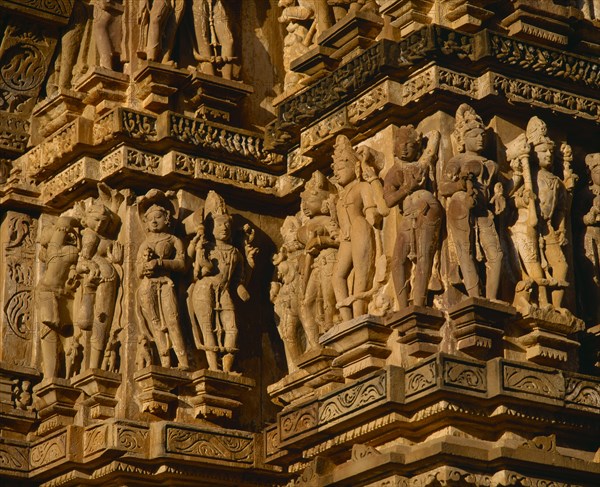 INDIA, Madhya Pradesh, Khajuraho, Vishvanath Temple. Detail of ornate carved figures around side.