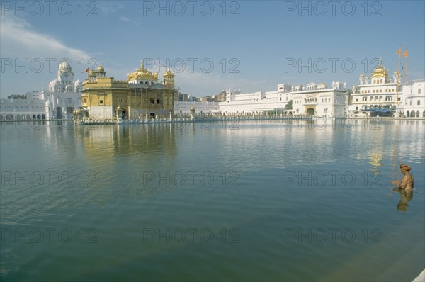 INDIA, Punjab, Amritsar , Sikh man praying in the sacred pool surrounding the Golden Temple.