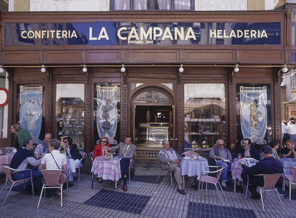 SPAIN, Andalucia, Seville, "Santa Cruz District, La Campana the most famous Pasteleria cake shop with people sitting at tables on the pavement"