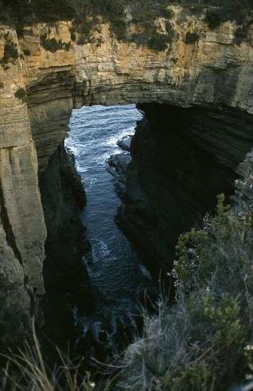 AUSTRALIA, Tasmania, Devils Kitchen, Near Eaglehawk Neck on the Tasman Peninsula.  Coastal rock formation forming natural arch.