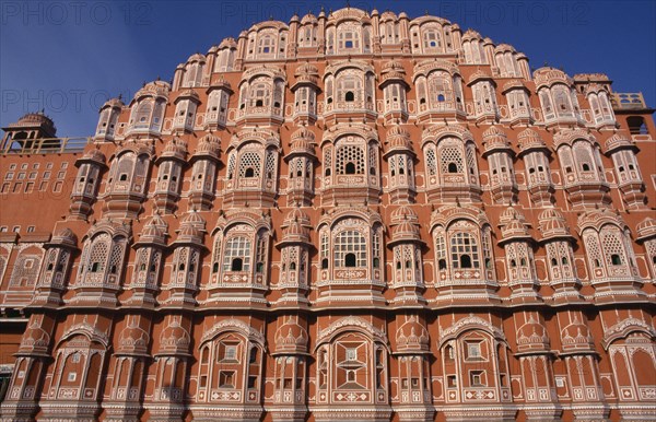 INDIA, Rajasthan, Jaipur, "Hawa Mahal or Palace of the Winds.  Cropped view of semi-octagonal, honeycombed pink sandstone exterior facade."