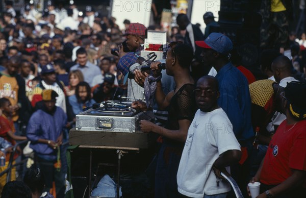 ENGLAND, London, Mixed crowd listening to sound system DJ and crew at the Notting Hill Carnival.