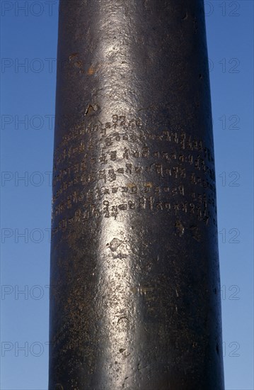 INDIA, Delhi, Qutab Minar Complex, 4th century AD Gupta pillar made of iron with Sanskrit inscription standing in mosque courtyard.