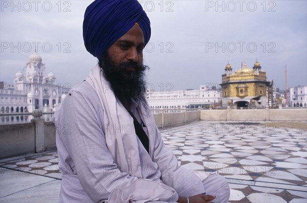 INDIA, Punjab, Amritsar , Golden Temple.  Sikh pilgrim with temple seen behind.