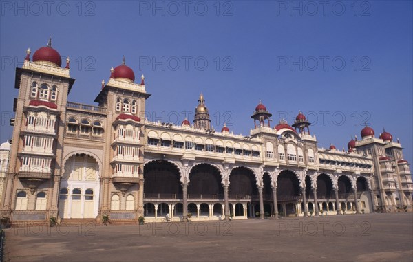 INDIA, Karnataka , Mysore , Angled view of exterior of Mysore Palace also known as Amba Vilas Palace with passing cyclist.