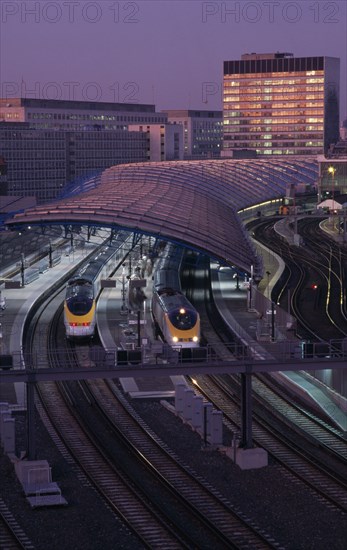 ENGLAND,  , London,  Waterloo Station International Terminal with Eurostar trains in evening.  City buildings behind.