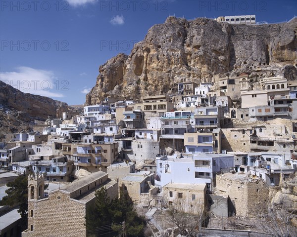 SYRIA, South,   Maalula, "Blue & white square houses built under & into rock face, churches "