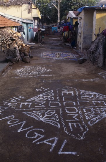 INDIA, Tamil Nadu, Festivals, Pongal Festival.  Four day festival to mark the end of harvest.  Painted welcome signs and decorative patterns on narrow street.