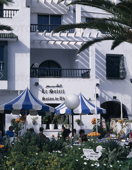 TUNISIA, Port El Kantaoui , Villas in an Arab style. Tourists sitting at tables outside cafe