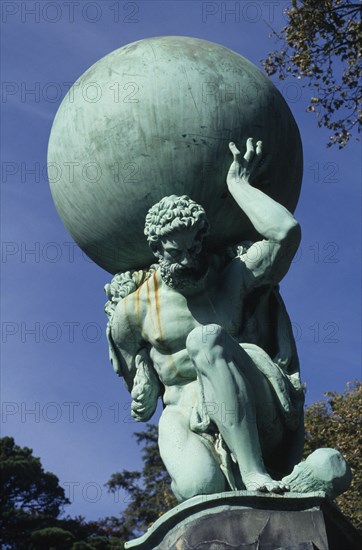 WALES, Gwynedd, Portmeirion, Nonesuch Statue depicting  life size nineteenth century copper figure of Hercules carrying sphere on his shoulders.