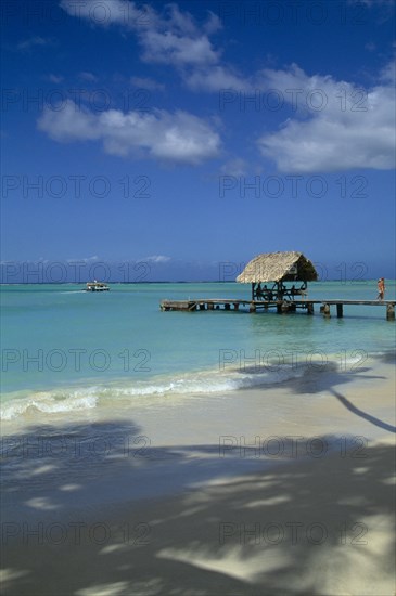 WEST INDIES, Tobago, Pigeon Point, View across shoreline toward wooden boat jetty with hut