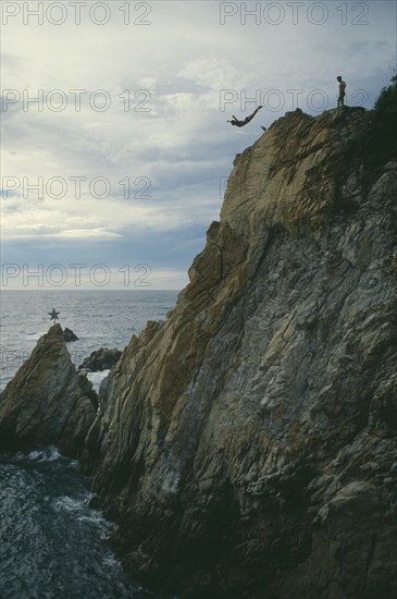 MEXICO, Guerrero, Acapulco, Cliff diver in mid air with sea below