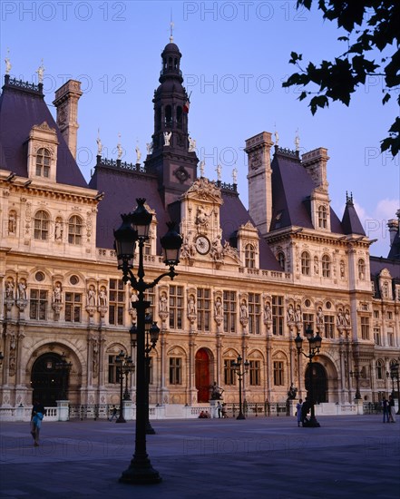 FRANCE, Ile de France, Paris, Hotel de Ville in evening. Exterior facade and courtyard with streetlamp in foreground.