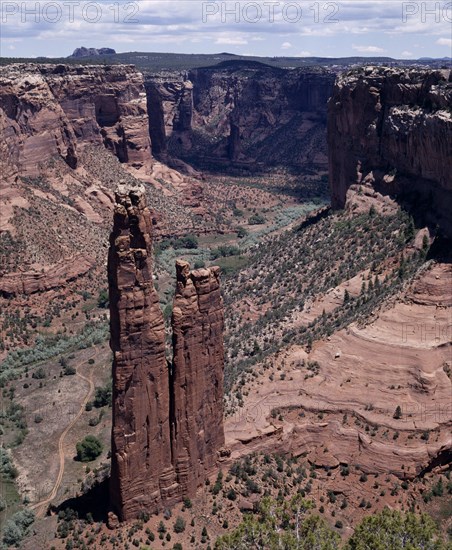 USA, Arizona, Canyon de Chelly, View looking down to Spider Rock with canyon beyond and scree slopes. A path cuts through canyon floor.