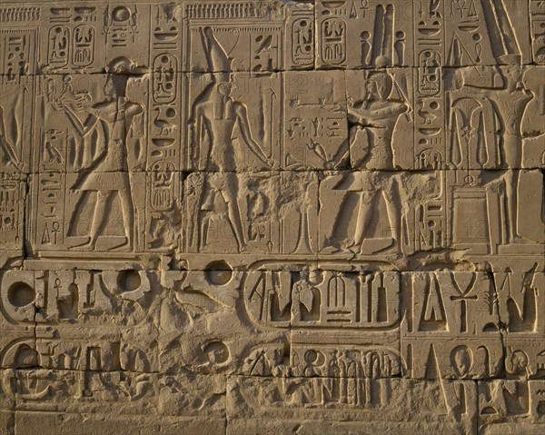 EGYPT, Nile Valley, Karnak, "Karnak Temple.  Hieroglyphic details carved in stone wall, people and symbols. "