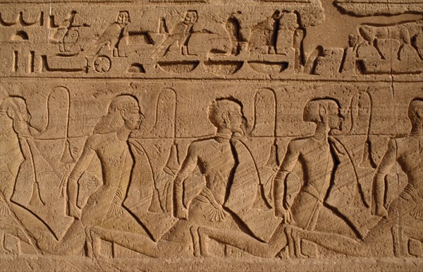 EGYPT, Abu Simbel, Hieroglyphics above relief carving of Nubian slaves