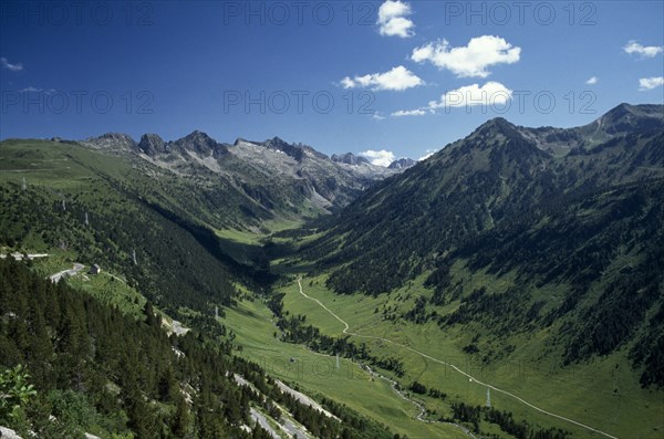 SPAIN, Pyrenees, Catalonia, Aran Valley.  River valley landscape with road following the course of the river and electricity pylons.