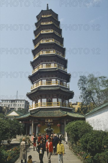 CHINA, Guangdong Province, Guangzhou, Octagonal Flower Pagoda within the compound of the Temple of the Six Banyan Trees.  Exterior view with people on the pathway outside.