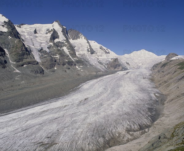 AUSTRIA, Karnten, Pasterze Glacier, View looking up glacier showing lateral moraine and mountainous sides with a blue sky above