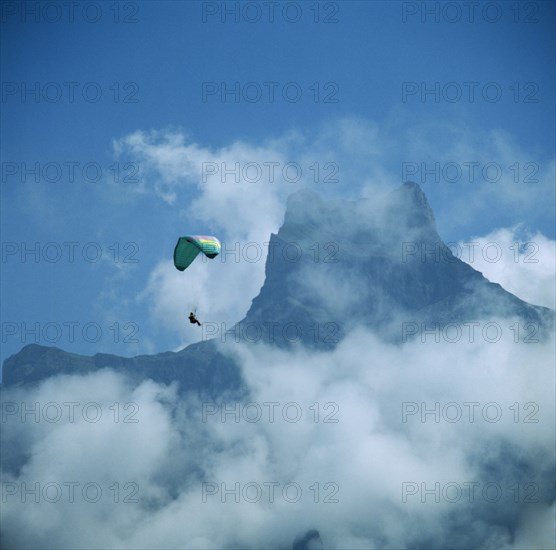 SWITZERLAND, Engelberg, View of mountain top through mist with paraglider
